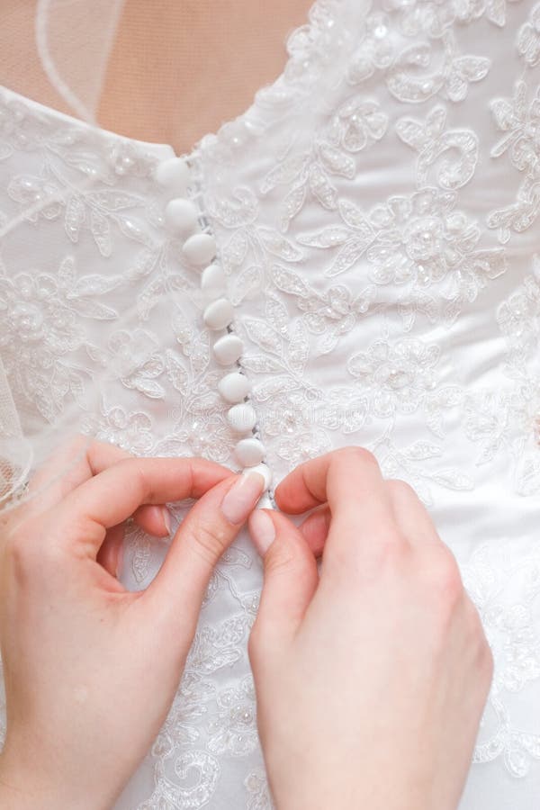 Hands of girls help to the bride to button a wedding dress. Button clasp stock images, royalty-free photos and pictures