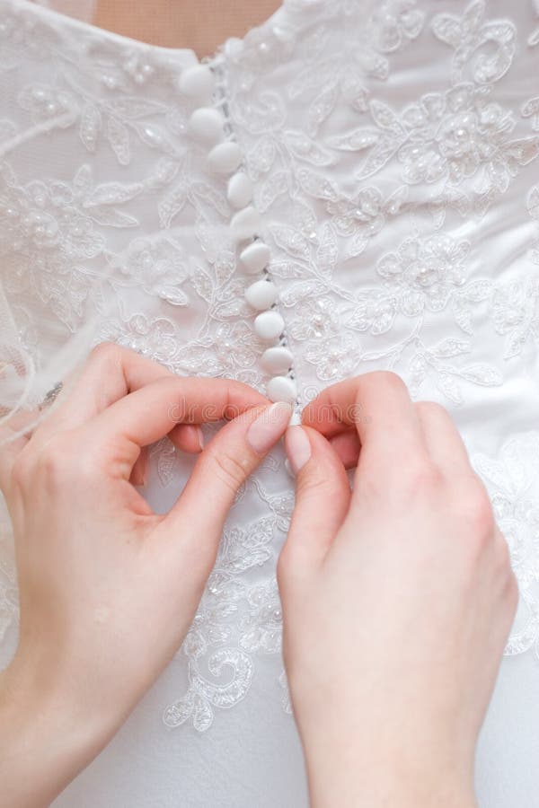 Hands of girls help to the bride to button wedding dress. Button clasp stock images, royalty-free photos and pictures