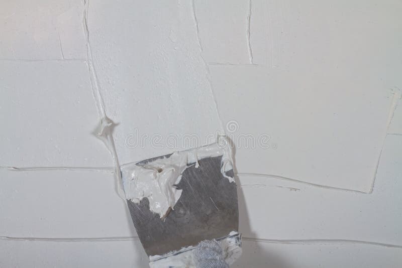 Putty the Wall in the House with Putty Using a Spatula To Level the