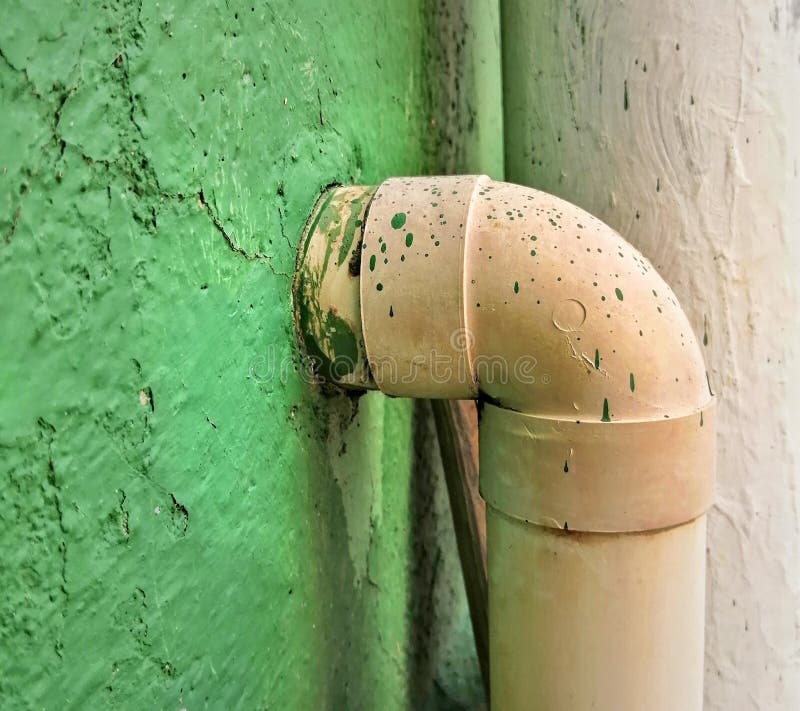 Pvc Plastic Tube in Green Wall with Dry Paint Drops on Top Stock Image