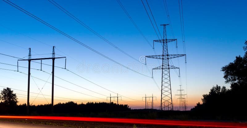 Pylons and electricity power lines at night with traffic lights in front. Red pylons stock images, royalty-free photos and pictures