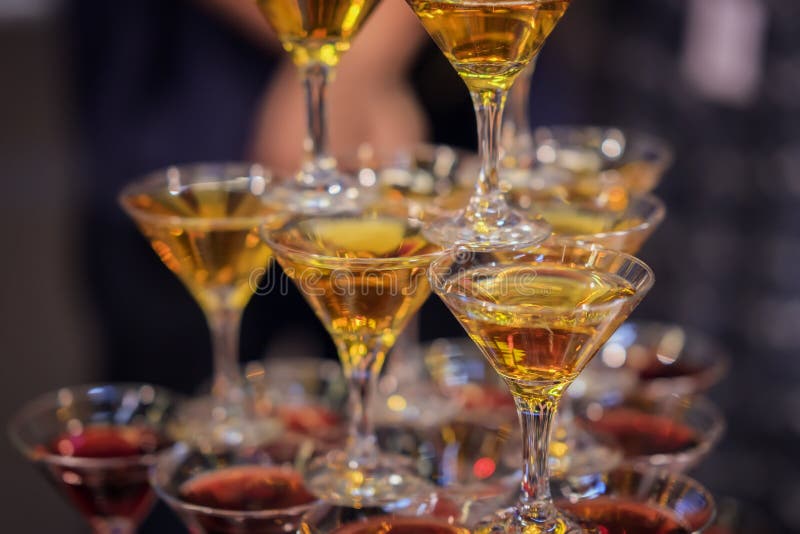 Pyramid of glasses with golden and red beverages, vine, wine, champagne, festive mood, celebration