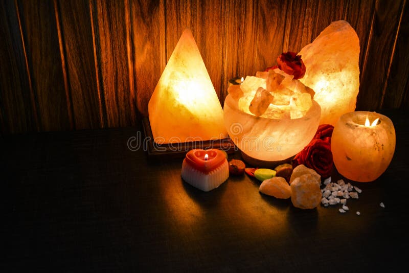 Glowing Pyramid, Bowl Chunks & Natural Salt Lamps with wooden & black background. Natural salt lamps are famous all over the world for their unique beautiful light. These salt lamps emit colorful apricot, yellow & orange light. These are carefully crafted from rock salt taken from mines in Salt Range Mountain located near Quaidabad, Khushab, Pakistan. Natural salt lamps are used to decorate drawing rooms, offices & bedrooms. It ionizes and purifies the air which can be very healthful for patients with asthma, joint pains & allergies. Today, the health benefits of ionizers are well recognized; whilst most ionizers in the market are manmade, the crystal salt lamps are Mother Nature`s beautiful alternative to cleanse & deodorize air. Glowing Pyramid, Bowl Chunks & Natural Salt Lamps with wooden & black background. Natural salt lamps are famous all over the world for their unique beautiful light. These salt lamps emit colorful apricot, yellow & orange light. These are carefully crafted from rock salt taken from mines in Salt Range Mountain located near Quaidabad, Khushab, Pakistan. Natural salt lamps are used to decorate drawing rooms, offices & bedrooms. It ionizes and purifies the air which can be very healthful for patients with asthma, joint pains & allergies. Today, the health benefits of ionizers are well recognized; whilst most ionizers in the market are manmade, the crystal salt lamps are Mother Nature`s beautiful alternative to cleanse & deodorize air.