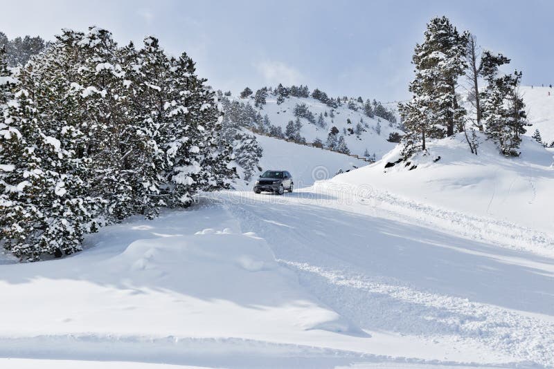 PYRENEES, ANDORRA - FEBRUARY 7, 2018: Test drive the Land Rover on a snow-covered road. Winter trail in the mountains, sunny