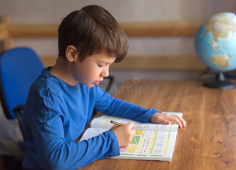 Pys som löser matematikövningsläxa royaltyfri fotografi Pys som löser matematikövningsläxa royaltyfri fotografi