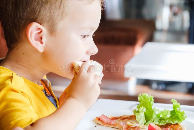 Pys som äter en liten pizza arkivbild Pys som äter en liten pizza arkivbild