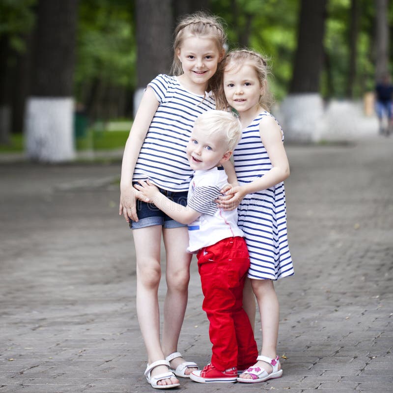 Blonde Little boy and two older cousins sisters, meeting in the summer park. Blonde Little boy and two older cousins sisters, meeting in the summer park