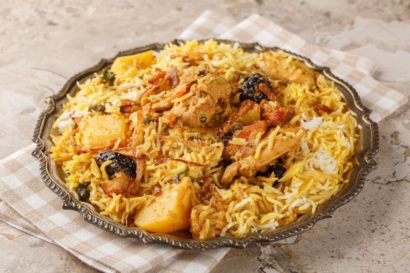 Pyszne pilaf kurczaka z ziemniakami basmati pomidory cebula i śliwki zamykające się w płytce. Poziomo zdjęcie royalty free