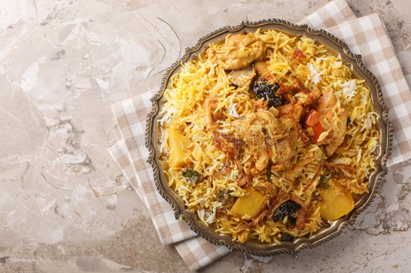 Pyszne pilaf kurczaka z ziemniakami basmati pomidory cebula i śliwki zamykające się w płytce. Poziomy widok górny zdjęcia stock