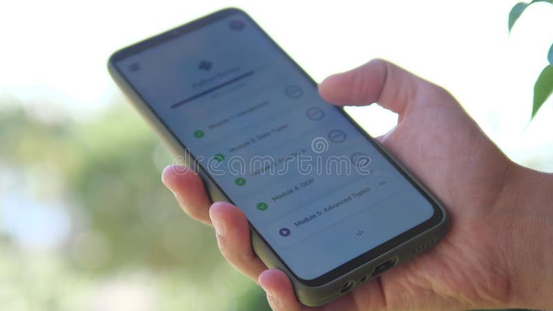 Κοντινό πλάνο ενός μαθητή που μαθαίνει προγραμματισμό Python μέσω μιας εφαρμογής για κινητά. Φιλικό προς το χρήστη περιβάλλον που φιλμ μικρού μήκους