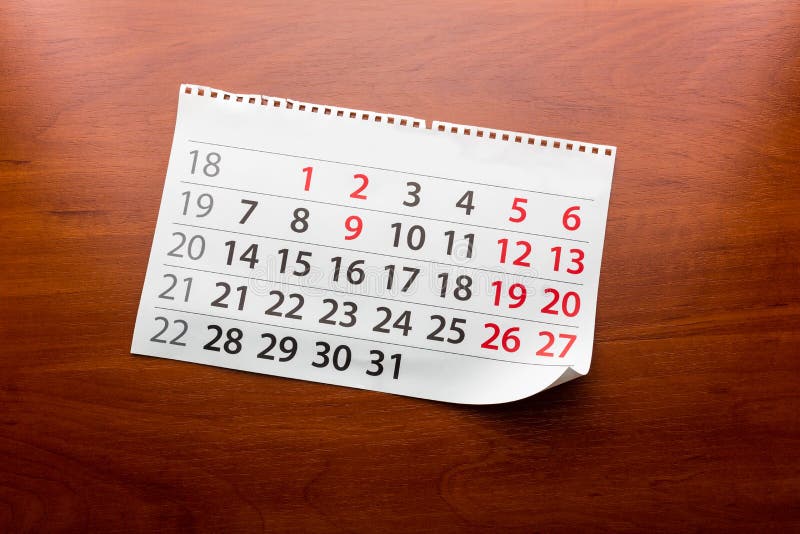 A página do calendário encontra-se na tabela fotos de stock A página do calendário encontra-se na tabela fotos de stock