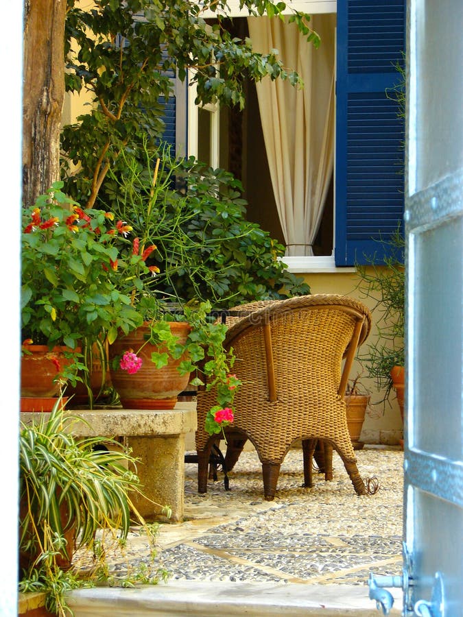 Plants and chairs on a comfortable patio or courtyard in Greece. Plants and chairs on a comfortable patio or courtyard in Greece.