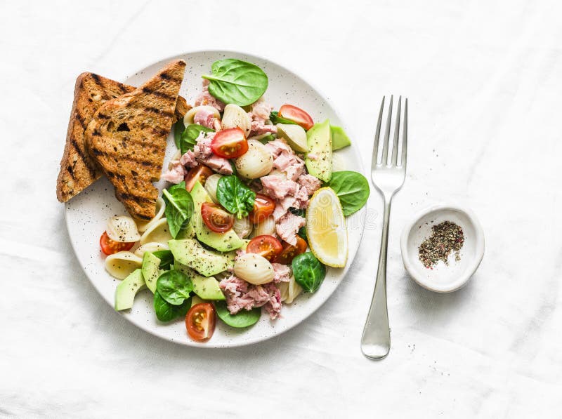 Pâtes d'Orecchiette, thon, avocat, épinards, salade de tomate et pain grillé entier de pain de grain - déjeuner sain délicieux photo stock Pâtes d'Orecchiette, thon, avocat, épinards, salade de tomate et pain grillé entier de pain de grain - déjeuner sain délicieux photo stock