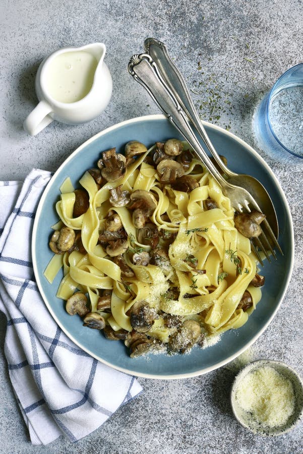 Pâtes de tagliatelles avec les champignons et le thym frits à une sauce crème Vue sup?rieure avec l'espace de copie images stock Pâtes de tagliatelles avec les champignons et le thym frits à une sauce crème Vue sup?rieure avec l'espace de copie images stock