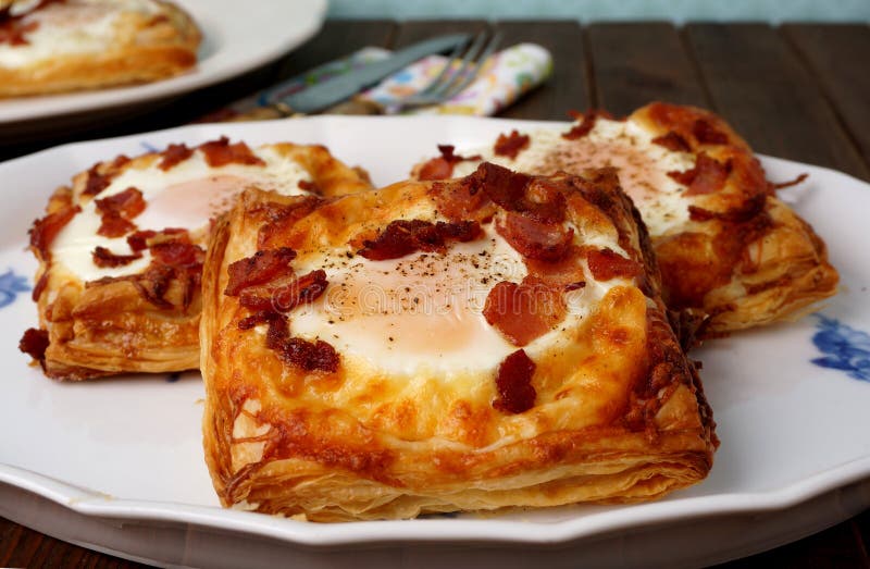 Pâtisseries danoises, petit déjeuner avec l'oeuf, lard, fromage et pâtes feuilletées photographie stock libre de droits Pâtisseries danoises, petit déjeuner avec l'oeuf, lard, fromage et pâtes feuilletées photographie stock libre de droits