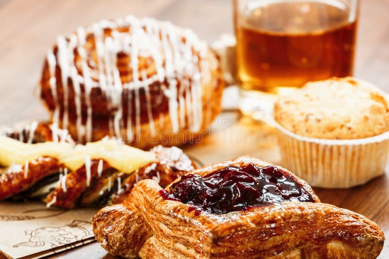 Pâtisseries, petits pains, gâteau de crème anglaise, un verre de jus de pomme sur la table Plan rapproché photos stock Pâtisseries, petits pains, gâteau de crème anglaise, un verre de jus de pomme sur la table Plan rapproché photos stock