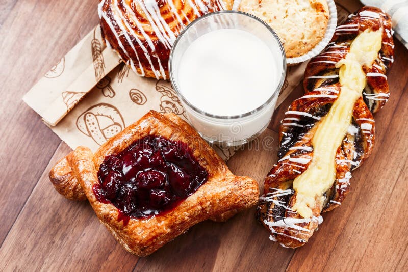 Pâtisseries, petits pains, gâteau de crème anglaise, un verre de lait sur la table Plan rapproché images libres de droits Pâtisseries, petits pains, gâteau de crème anglaise, un verre de lait sur la table Plan rapproché images libres de droits