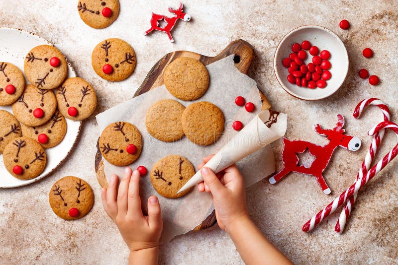 Pão de Natal Bolachas de rena ruidosa, decoradoras de crianças, com botões de chocolate e chocolate derretido fotografia de stock