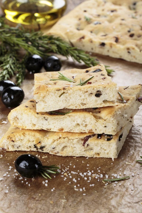 Pão italiano do focaccia com azeitonas e alecrins fotos de stock royalty free Pão italiano do focaccia com azeitonas e alecrins fotos de stock royalty free