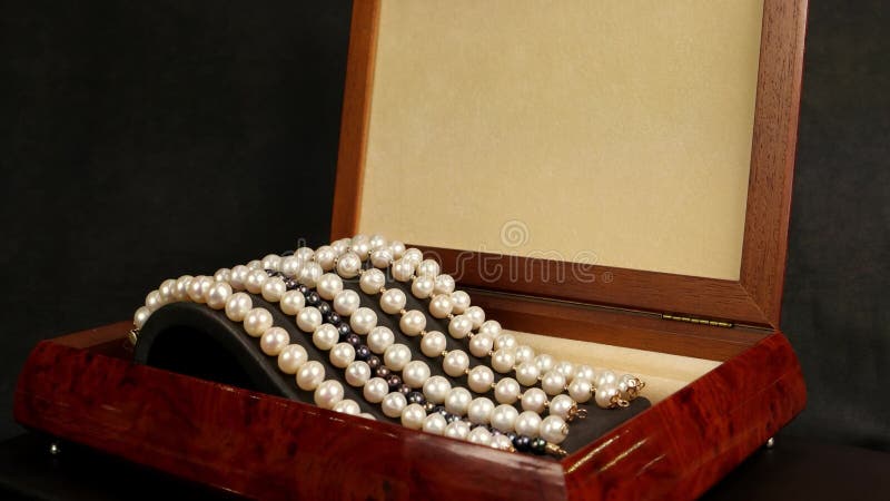 Pärlemorfärg armband i den bruna träcasketen, smycken som göras av pärlor, pärlemorfärg armband på en sockelgarnering för glamorö