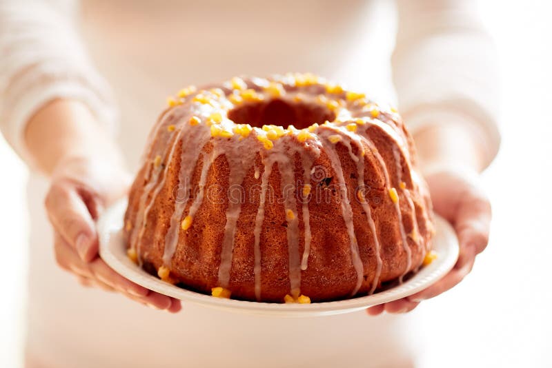 Påskjästkaka på en vit platta som rymms av kvinnliga händer, när du tjänas som till tabellen royaltyfria foton Påskjästkaka på en vit platta som rymms av kvinnliga händer, när du tjänas som till tabellen royaltyfria foton