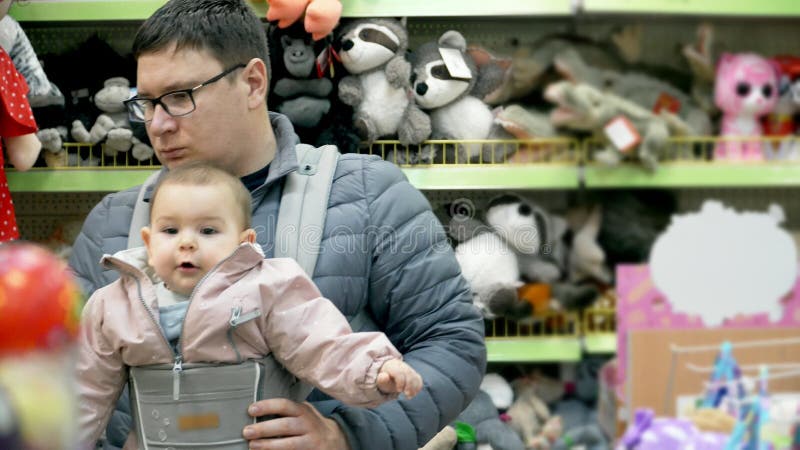 Père avec son enfant dans le transporteur de bébé dans le centre commercial, concept de parenting d'attachement