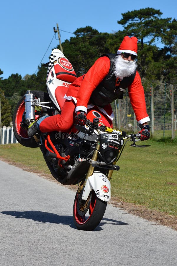 Père Christmas faisant le wheelie de roue avant photo stock Père Christmas faisant le wheelie de roue avant photo stock