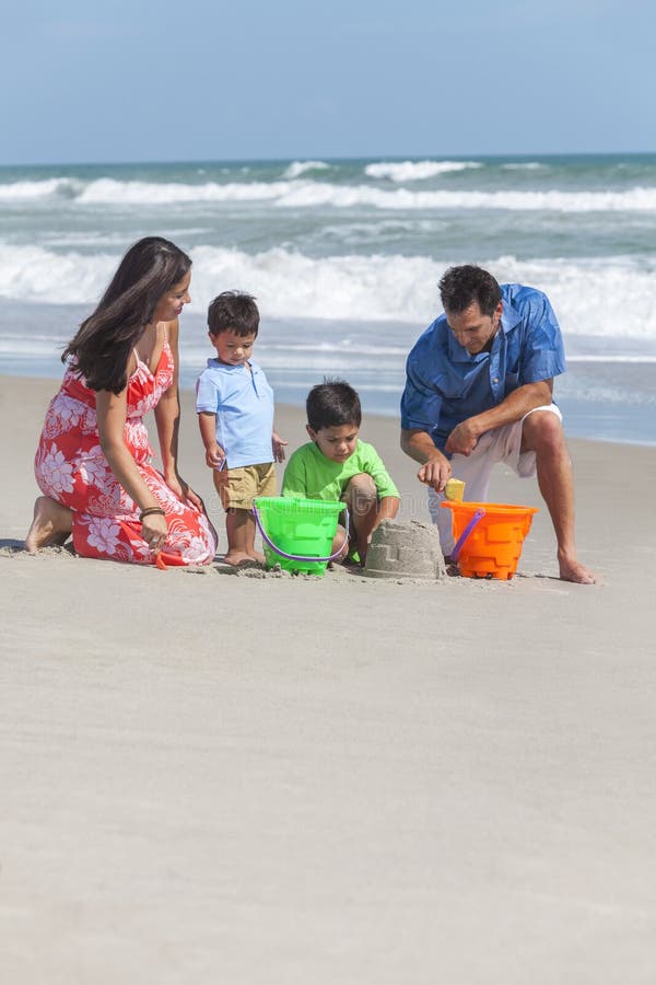 Père de mère et famille d'enfants jouant sur la plage photographie stock