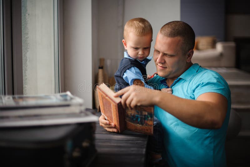 Père de sourire heureux et petit livre de lecture de fils photos libres de droits Père de sourire heureux et petit livre de lecture de fils photos libres de droits