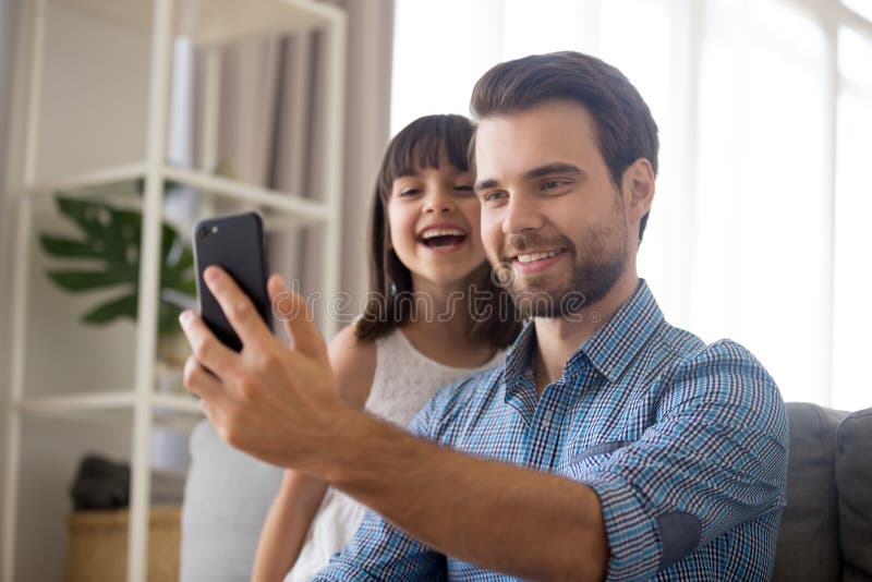 Père de sourire prenant le selfie avec la fille mignonne d'enfant sur le smartphon photos libres de droits Père de sourire prenant le selfie avec la fille mignonne d'enfant sur le smartphon photos libres de droits
