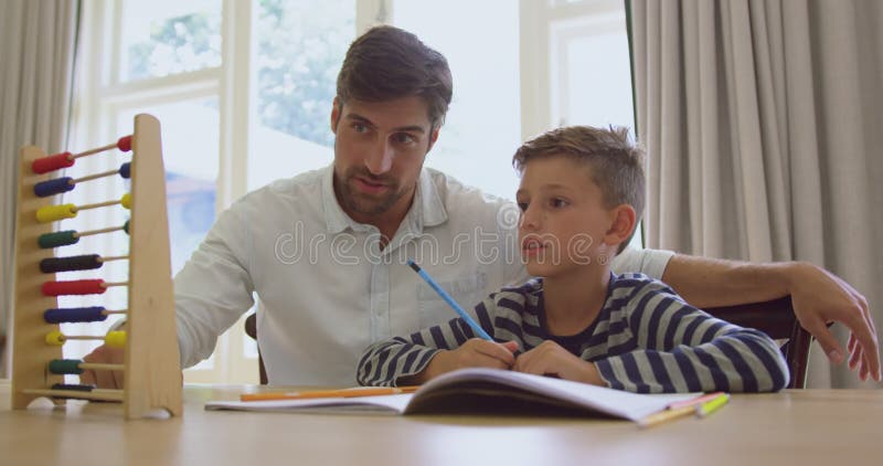 Père enseignant ses mathématiques de fils avec l'abaque dans une maison confortable 4k clips vidéos