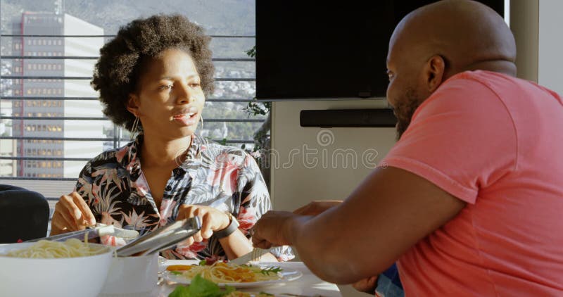 Père enseignant son fils mangeant avec la fourchette et le couteau à la table de salle à manger 4k clips vidéos