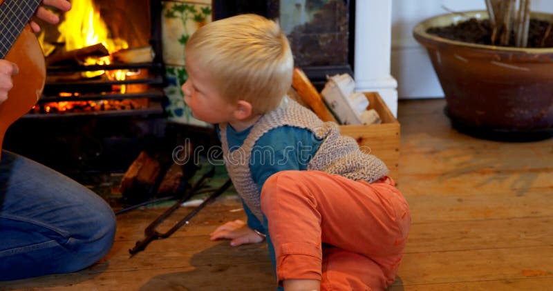 Père enseignant son fils à jouer la guitare dans le salon à la maison 4k clips vidéos