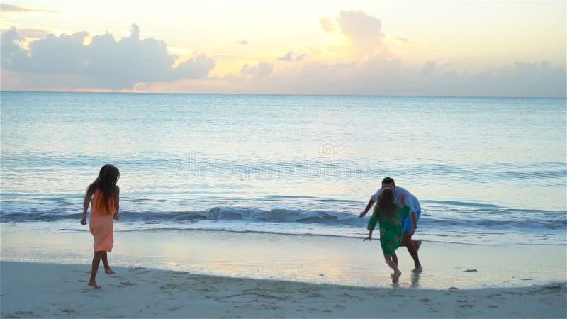 Père et enfants appréciant des vacances tropicales d'été de plage au coucher du soleil Mouvement lent clips vidéos