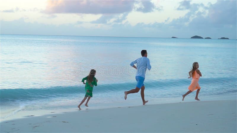Père et enfants appréciant des vacances tropicales d'été de plage Mouvement lent banque de vidéos
