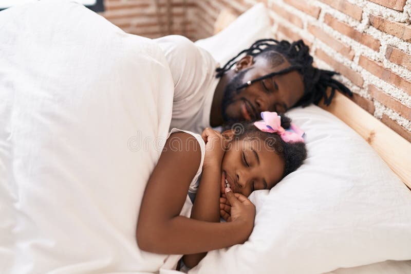 Père et fille couchés dans le lit dormant dans la chambre images libres de droits