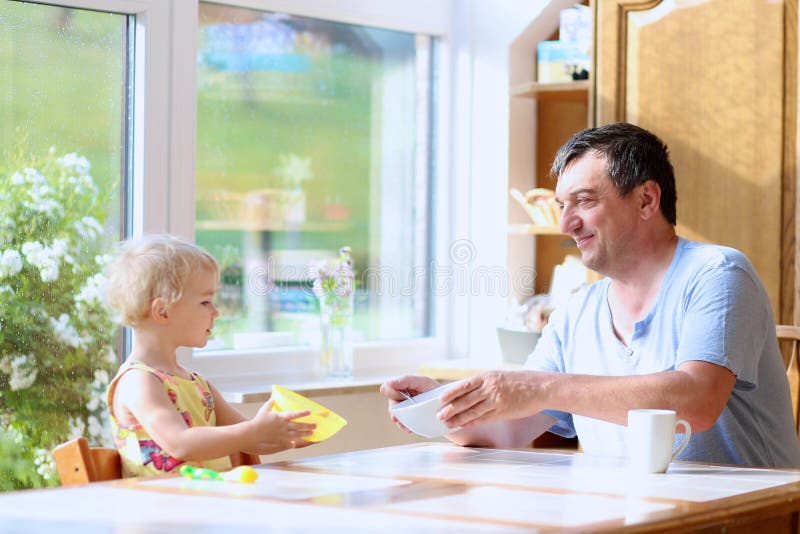 Père et fille prenant le petit déjeuner photographie stock Père et fille prenant le petit déjeuner photographie stock