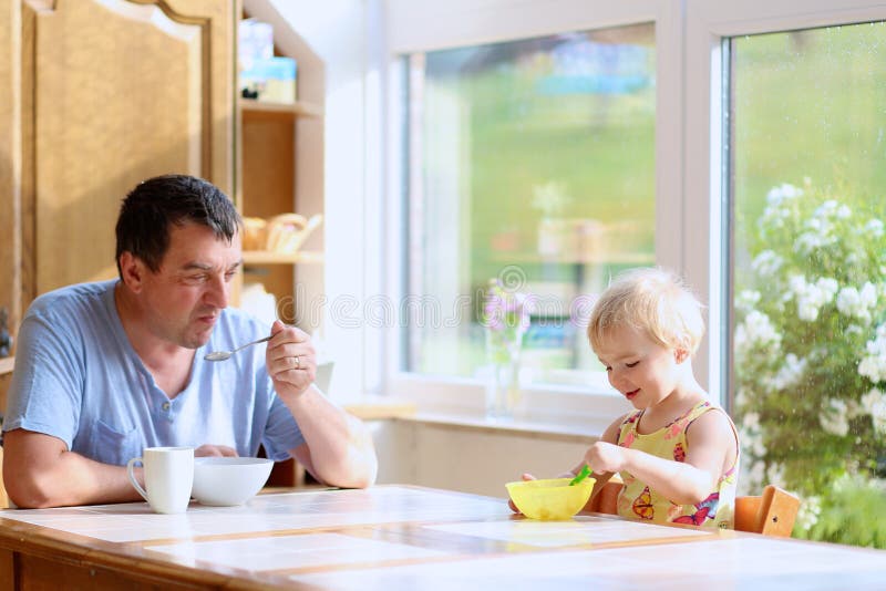 Père et fille prenant le petit déjeuner images stock Père et fille prenant le petit déjeuner images stock