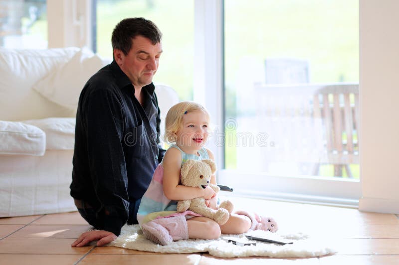 Père et fille regardant la TV à la maison images stock Père et fille regardant la TV à la maison images stock