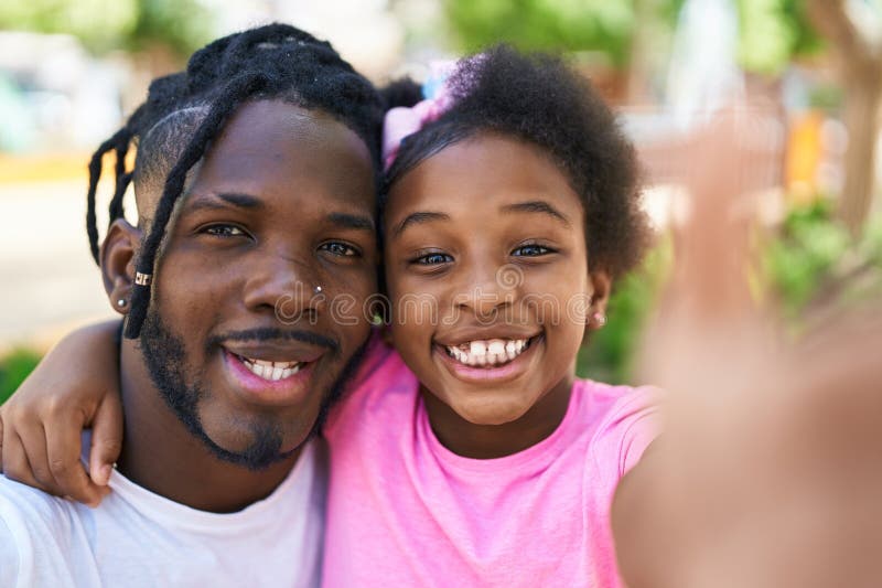 Père et fille souriant confiant faire le selfie par caméra au parc photos stock