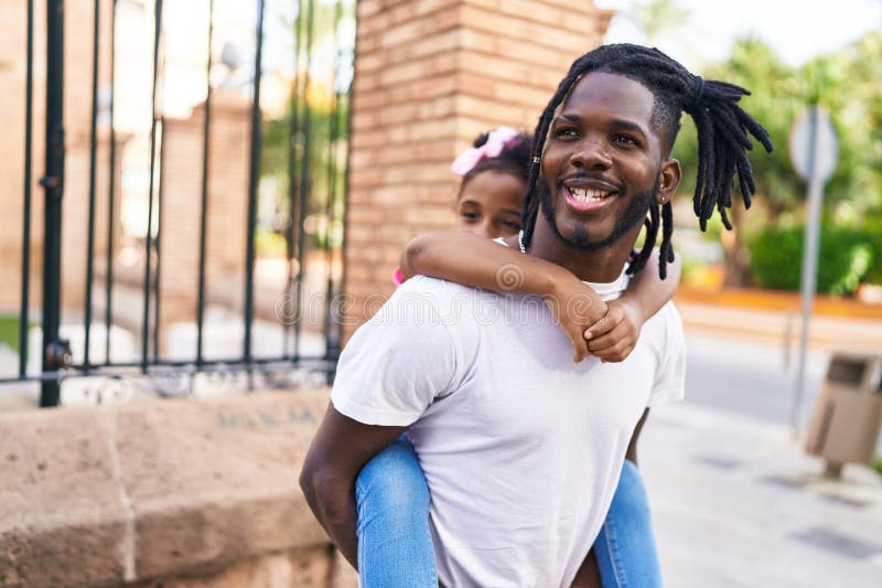 Père et fille souriant confiant tenant fille dans le dos à la rue images libres de droits