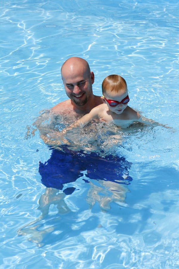 Père et fils de sourire dans la piscine photo libre de droits Père et fils de sourire dans la piscine photo libre de droits