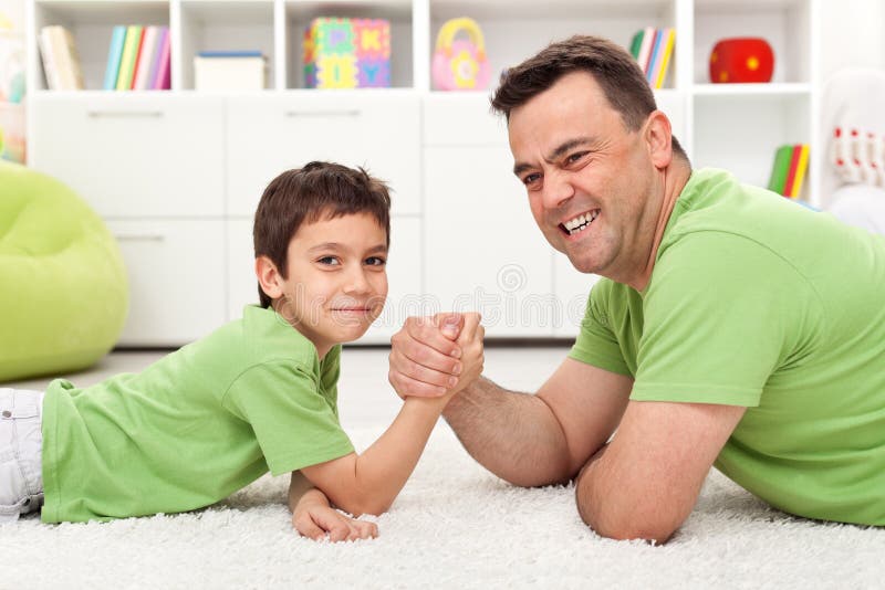 Père et fils jouant la lutte de bras photo stock Père et fils jouant la lutte de bras photo stock