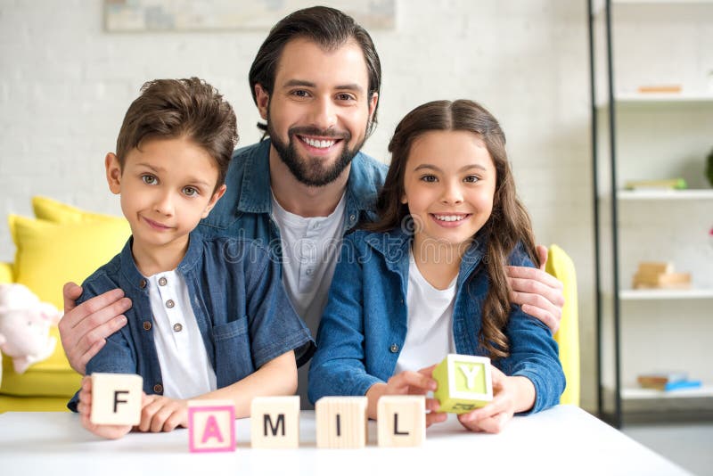 père heureux avec deux enfants tenant des cubes avec la famille et le sourire de mot images stock père heureux avec deux enfants tenant des cubes avec la famille et le sourire de mot images stock