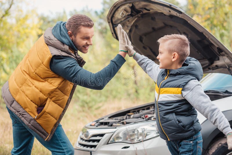père heureux et fils donnant la haute cinq tout en réparant la voiture images libres de droits père heureux et fils donnant la haute cinq tout en réparant la voiture images libres de droits