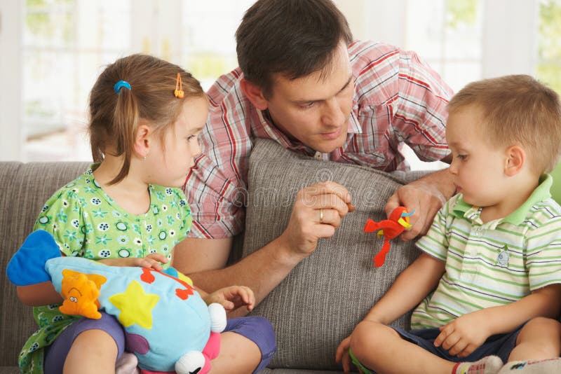 Père jouant avec des enfants à la maison images stock Père jouant avec des enfants à la maison images stock