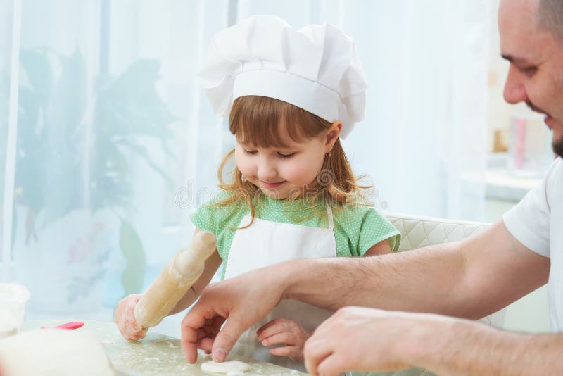 Père préparant la nourriture avec ma fille un homme enseigne un enfant à faire cuire le processus de la cuisson dans une cuisine photos libres de droits Père préparant la nourriture avec ma fille un homme enseigne un enfant à faire cuire le processus de la cuisson dans une cuisine photos libres de droits