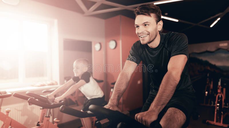 Père And Son Training sur la traînée de vélo dans le gymnase photos stock Père And Son Training sur la traînée de vélo dans le gymnase photos stock