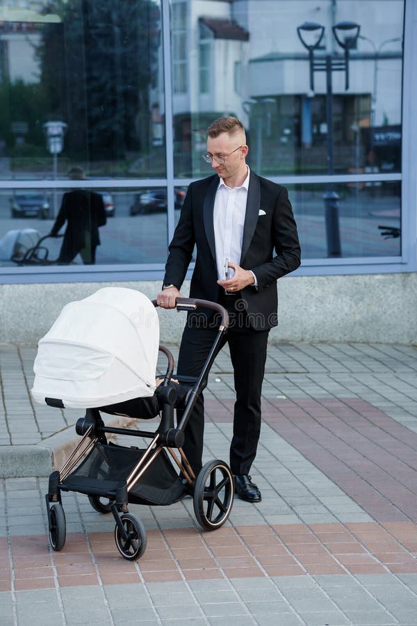 Père élégant flâner avec poussette moderne en milieu urbain photos libres de droits