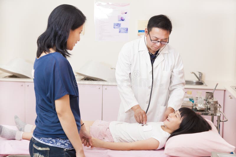 Pédiatre à l'aide du stéthoscope à la petite fille d'examen photo stock Pédiatre à l'aide du stéthoscope à la petite fille d'examen photo stock